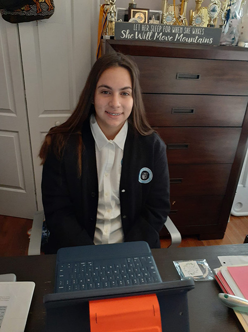 Clad in her school uniform, Our Lady of Lourdes Academy freshman Sabrina Fernandez is ready to start learning as the 2020-2021 school year begins, online for now, Aug. 19, 2020.