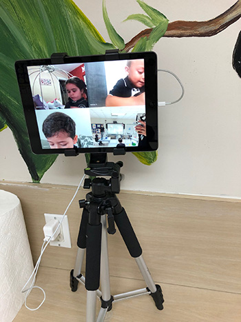 PreK4 students learning from home are visible on a tripod-mounted iPad to their teacher at Mother of Our Redeemer School, Miami, on the first day of school, Aug. 19, 2020.