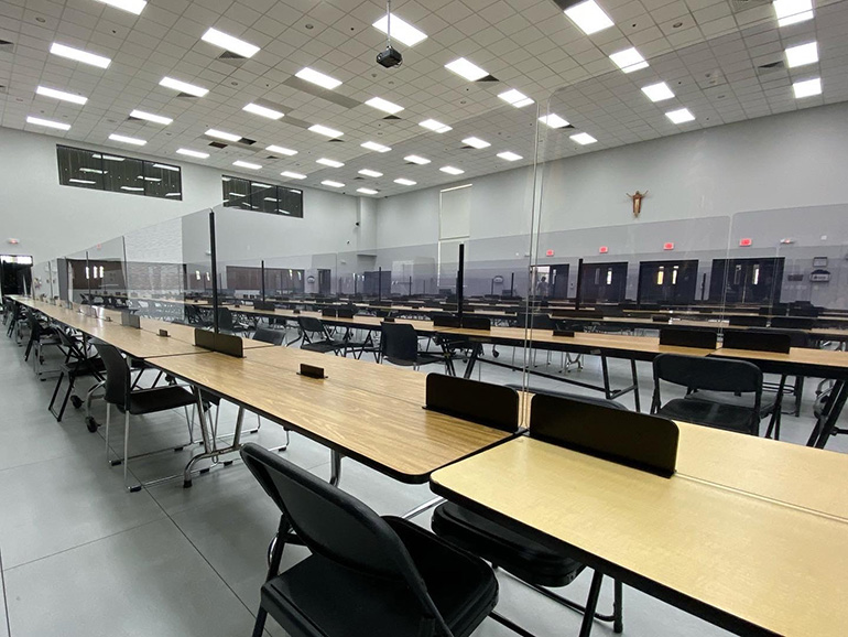Divisores de plexiglás separan las mesas de la cafetería de la Secundaria Msgr. Edward Pace, mientras la escuela se prepara para reanudar las clases, de forma virtual por ahora, el 19 de agosto de 2020.