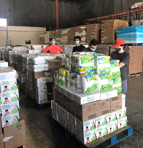 Belen Jesuit students are shown here volunteering at a warehouse in Doral, where they helped sort donations of baby goods to benefit parishes and local pregnancy help centers associated with the archdiocese's Respect Life Ministry.