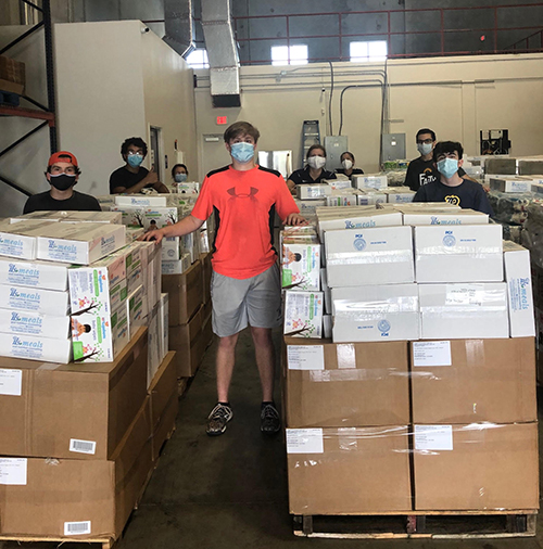 Belen Jesuit students are shown here volunteering at a warehouse in Doral, where they helped sort donations of baby goods to benefit parishes and local pregnancy help centers associated with the archdiocese's Respect Life Ministry.