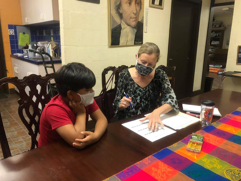 La especialista en lectura del Centro Educativo La Salle, Brenda Blanton, guía a un estudiante con su tarea. Blanton fue contratada originalmente para ayudar con el "tobogán de verano", un término que se refiere a los meses de verano cuando las habilidades académicas son a veces olvidadas por los estudiantes. Cuando COVID-19 hizo que las escuelas y las tareas fueran virtuales, Blanton ayudó a los estudiantes a adaptarse y mantenerse al día con sus estudios.