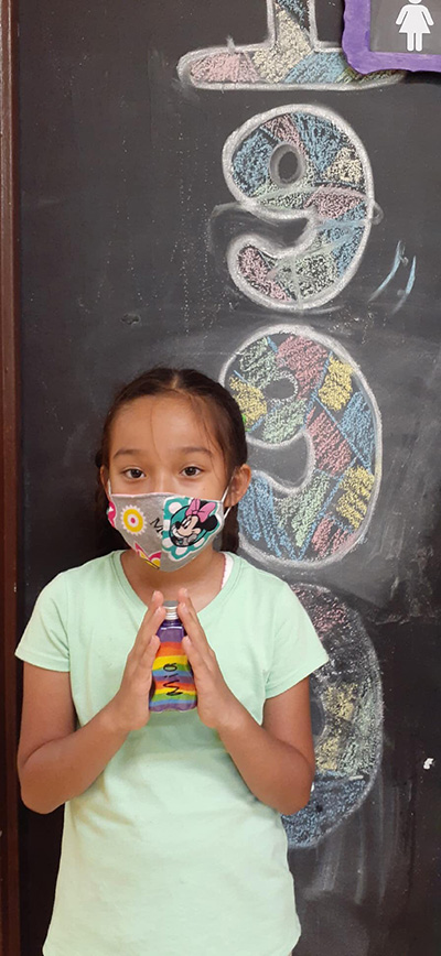 Rainbows and sand art: A summer camper at La Salle Educational Center shows off the bottled sand art she made, an iconic craft of the 1990s.