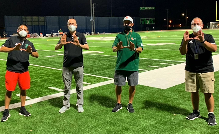 Making the U at the B, from left: St. Brendan High School Athletic Director Kevin Esteban; Principal Jose Rodelgo-Bueno; University of Miami Head Coach Manny Diaz; and St. Brendan Assistant Principal Guillermo Ramos.