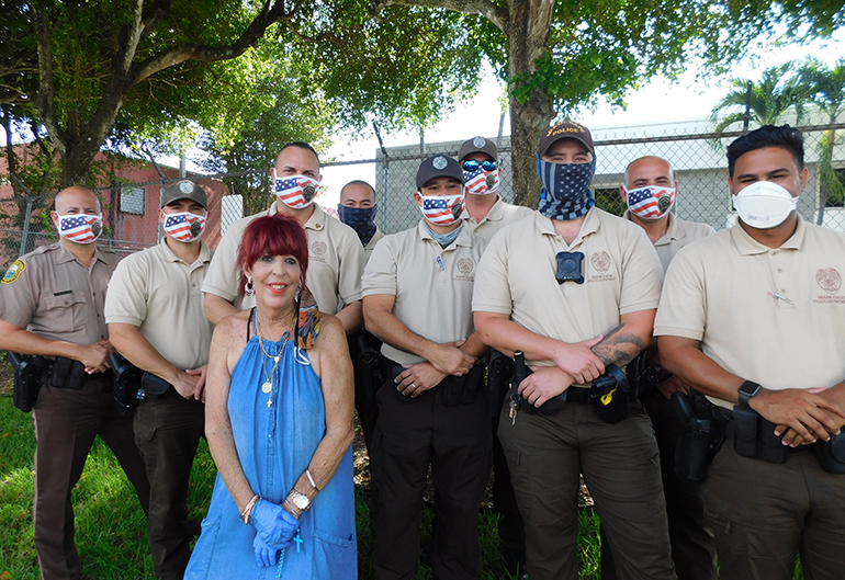 Jossie Flores, directora del Banco de Comida de la Sociedad San Vicente de Paúl posa junto al grupo de agentes policiales que apoya cada sábado la distribución de alimentos en el almacén ubicado al suroeste de Kendall. Desde la izquierda los oficiales: Jeovanni Cruz, Leonel Cobo, Joshua Brunner, Christopher Rodríguez, el sargento Luis Medina, Phu Nguyen, el Sargento Framis Ramos, Anthony Menéndez y Jorge Guzmán.