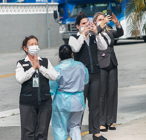 Devotos de la Virgen de la Caridad, en este caso empleados de Leon Medical Center, la saludan y toman fotos durante el recorrido de la Ermita hasta la iglesia St. Michael en Miami.