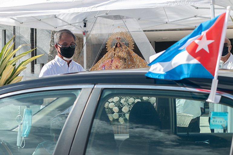 La imagen de la Virgen de la Caridad permanece expuesta a la entrada de la iglesia St. Michael en Miami mientras los fieles pasan a saludarla, recitan una breve oración, y dejan ofrendas de flores y dinero.