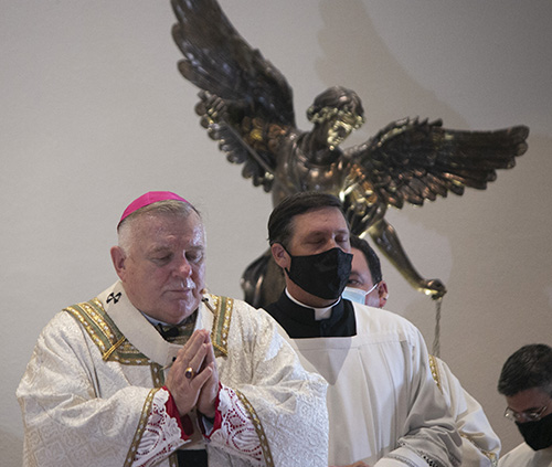 El arzobispo Thomas Wenski reza durante la celebración de la fiesta de Nuestra Señora de la Caridad, el 8 de septiembre de 2020, que debido a la pandemia de COVID-19 tuvo lugar en la iglesia de St. Michael en Miami con una asistencia reducida y socialmente distanciada. A la derecha está el maestro de ceremonias del arzobispo y director de la Oficina de Culto, el P. Richard Vigoa.