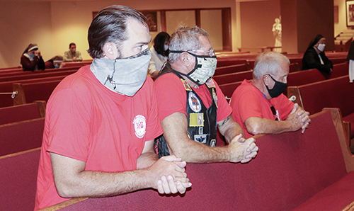 Knights on Bikes Tony Orband, Lance Maki and Dale Saunders pray while celebrating Mass with Archbishop Thomas Wenski Sept. 17, 2020, during a stop at the archdiocesan Pastoral Center in Miami Shores. They were riding to northern Florida along U.S. 1 to raise awareness about the rights enshrined in the First Amendment to the U.S. Constitution, notably freedom of religion and speech.