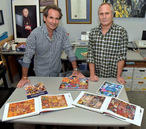 Marc Swedroe, left, and Freddy Sall show books of artwork by artist Robert Swedroe.