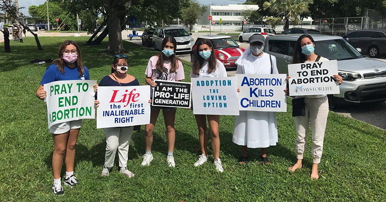 Students from Immaculata-La Salle High School in Miami, along with their morality teacher, Salesian Sister Marie Fe Tansioco, pose with their signs while taking part in the Life Chain along U.S. 1 on Respect Life Sunday, Oct. 4, 2020. At the end of September, the school's Marian Club and Life is a Gift Club sponsored a diaper drive for the Miami Diaper Bank which collected more than 12,000 diapers, and over 50 boxes of diaper wipes.