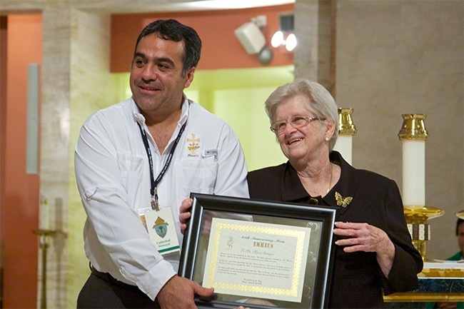 During Emmaus' 35th anniversary celebration, Myrna Gallagher receives a certificate for her inspiration and commitment in creating the weekend, which has changed the spiritual lives of thousands. Next to her is Guillermo Salomón, an Emmaus brother from Our Lady of Guadalupe Church in Doral.