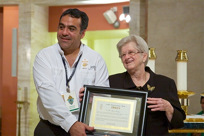 Durante la celebración del 35 aniversario de Emaús, Myrna Gallagher recibe un certificado por su inspiración y compromiso en la creación del retiro de fin de semana, que ha cambiado la vida espiritual de miles de personas. Junto a ella está Guillermo Salomón, un hermano de Emaús de la iglesia Our Lady of Guadalupe, en Doral.