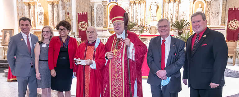 Posing after Archbishop Thomas Wenski celebrated the annual Red Mass hosted by the Miami Catholic Lawyers Guild, Oct. 29, 2020, are representatives of St. Thomas University, title sponsor for the event; from left: STU Law School Assistant Deans Jorge Cos and Lourdes B. Fernandez; Dean Tamara Lawson; Father Eddie Alvarez, pastor of Gesu Church and the guild's spiritual advisor; Archbishop Wenski; Francis Sexton, president of the Miami Catholic Lawyers Guild; and David Armstrong, president of St. Thomas University. At the Mass, the guild presented its annual Lex Christi, Lex Amoris award to Catholic Legal Services of the Archdiocese of Miami.