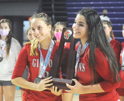 Cardinal Gibbons senior captains Manuela Williamson, left, and Valeria Lozada pose with the runner-up trophy after the FHSAA Class 4A volleyball state final match Nov. 15, 2020 at Suncoast Credit Union Arena in Fort Myers. Bishop Kenny defeated Cardinal Gibbons 29-27, 25-18, 17-25, 25-20 to win their third state title.