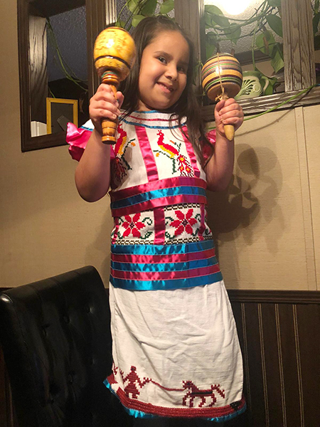 La niña Catalina Uribe, vestida con su traje tradicional de Guatemala, desde Misisipi, participó en el campamento virtual con niños de la escuela St. Hugh, en Miami.