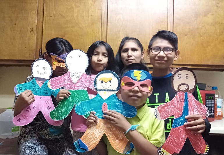 La señora Isabel Ramos con sus tres hijos y un sobrino, desde Misisipi, participan en una actividad del campamento virtual con niños de la escuela St. Hugh, en Miami.