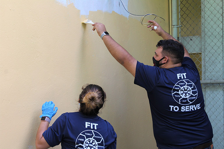 Just a little higher: Anthony Perez-Florido helps Solanghe Rodriguez paint a spot out of her reach. The two, who work with Hancock, Askew and Co., volunteered with others from their accounting firm to beautify Catholic Charities of the Archdiocese of Miami's Notre Dame Child Development Center in Little Haiti, Nov. 5, 2020. The accountants and auditors at Hancock, Askew and Co. participate twice a year in community service projects across the state.