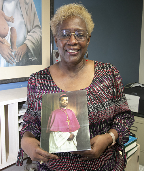 Katrenia Reeves-Jackman, director of the archdiocesan Office of Black Catholic Ministry, holds up a picture of a very young bishop, now Cardinal-elect Wilton Gregory of Washington, D.C., the first African-American to be elevated to that rank.