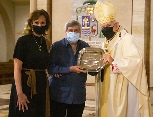 Archbishop Thomas Wenski gives Henry and Grace Lopez-Aguiar the One in Faith award during the Thanks-for-Giving Mass celebrated at St. Mary Cathedral, Nov. 21, 2020.