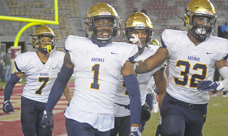 Ja'Den McBurrows (1) joins teammates Tyson Russell (7) and Jaydon Hood (32) in celebrating McBurrows' 46-yard interception return for a touchdown late during the first half of St. Thomas Aquinas' 31-21 victory over Orlando Edgewater, Dec. 19, 2020, in the FHSAA Class 7A Football State Championship Game at Bobby Bowden Field at Doak Campbell Stadium. The Raiders won their state-record 12th title.