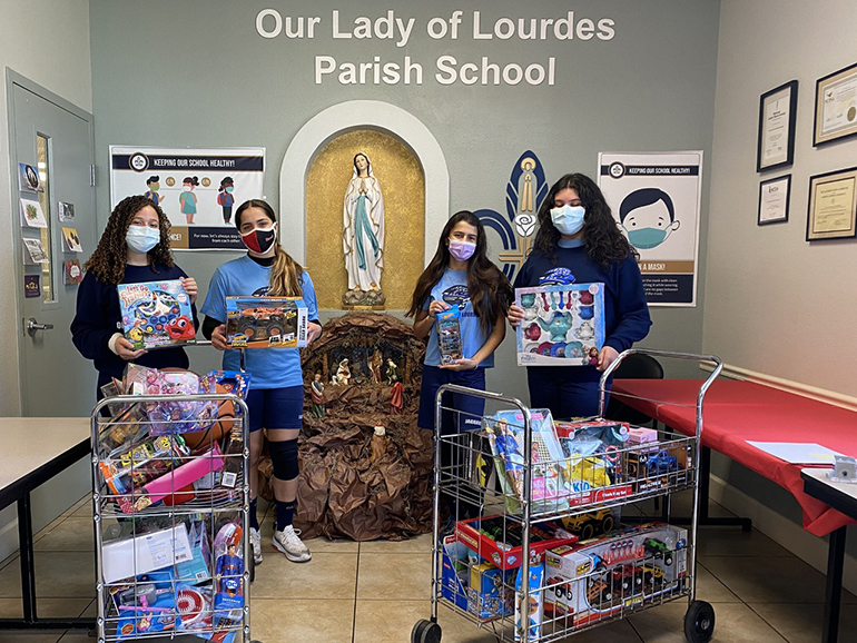 Students from Our Lady of Lourdes School in Miami pose with some of the more than 300 toys students collected for Las Hormiguitas del Senor (God's Little Ants) in the Redland.