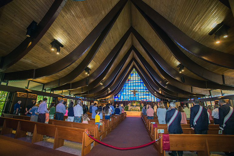 Vista del interior de la iglesia St. Hugh durante la Misa del 60 aniversario, muestra una de las características más destacadas del edificio, las 28 vigas de madera inclinadas. El Arzobispo Thomas Wenski celebró la Misa del 60 aniversario, el 15 de noviembre de 2020.