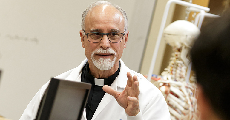 El P. Alfred Cioffi, director del Programa de Maestría en Bioética de la Universidad St. Thomas, en esta fotografía de archivo del 2016, da una clase de biología a sus estudiantes. Durante una transmisión vía Facebook Live de la Arquidiócesis de Miami, el 8 de enero de 2021, señaló que vacunarse es una doble responsabilidad para cuidar de uno mismo y para no infectar a los demás.