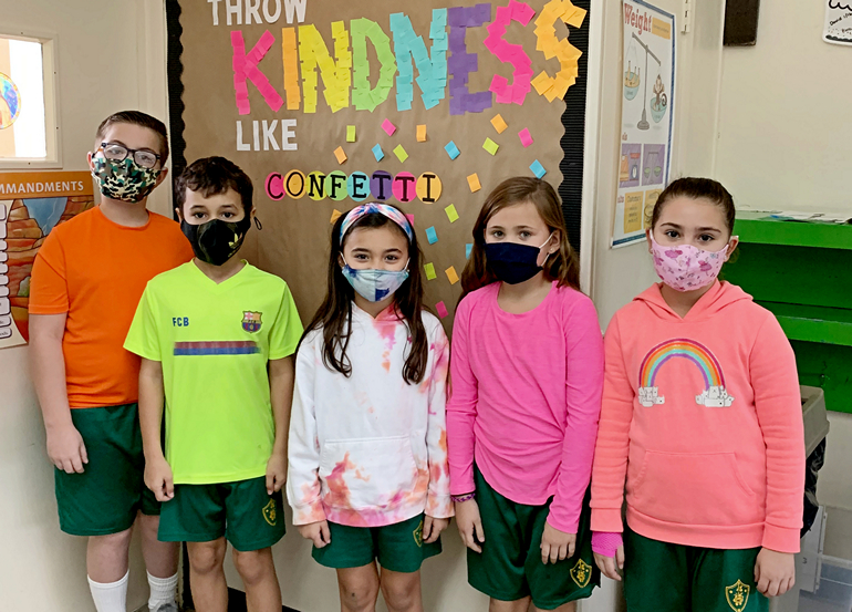 Students at St. Theresa School wear rainbow shirts and mismatched socks, literally modeling a theme of loving people through their differences.