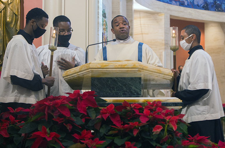 Transitiional Deacon Franklyn Ekezie, a native of Nigeria, proclaims the Gospel in his native tongue, Igbo, during the annual Migration Mass, celebrated by Archbishop Thomas Wenski at St. Mary Cathedral on the feast of the Epiphany, Jan. 3, 2021.