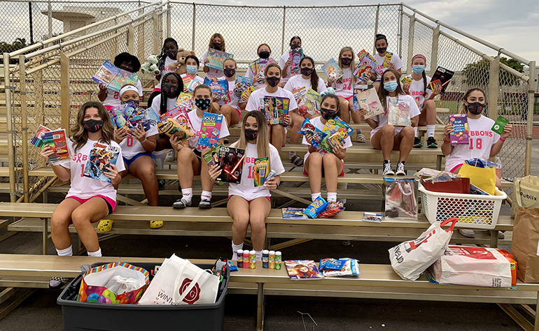 Cardinal Gibbons girls' soccer players pose with some of the donations collected at the Coaches vs. Cancer game held Jan. 13, 2021 on the Gibbons field.