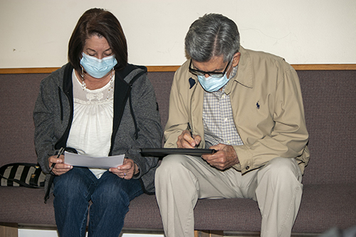 Elizabeth and Dagoberto Rodriguez, 75 and 79 respectively, fill out health information before getting the Moderna COVID-19 vaccine at their parish, San Lazaro in Hialeah, Jan. 20, 2021.