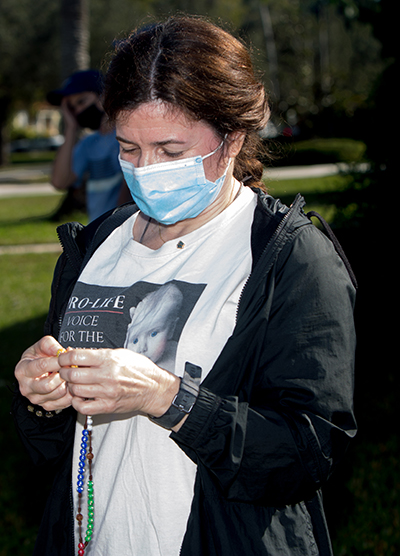 Lili Bandrich, from Gesu Church, prays the rosary. She was one of nearly 200 Blessed Trinity parishioners and others who took part in a Prayer Walk For Life along Curtiss Parkway in Miami Springs, Jan. 23, 2021.