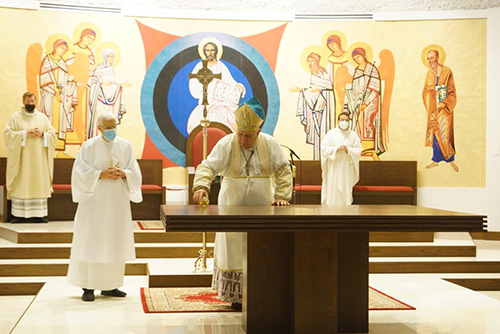 Archbishop Thomas Wenski pours oil of chrism on the new altar at Mother of Christ Church in Miami, Jan. 1, 2021. He also blessed the refurbished worship space. Behind him is a painting of Christ Pantocrator which will also be getting a touch-up soon.