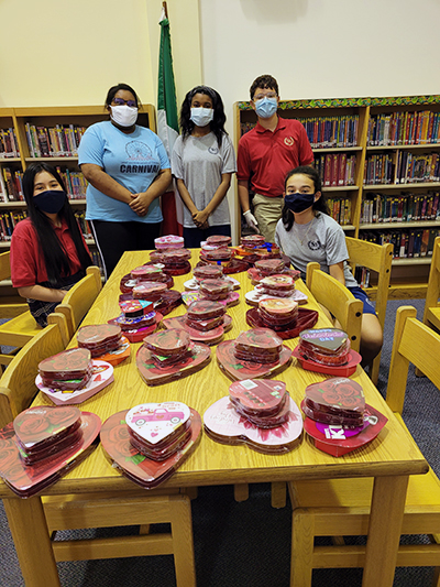 Students at St. Andrew School pose with some of the chocolate candy they collected for health care workers and first responders doing COVID-19 testing at Mullins Park, which is located behind the Coral Springs school. The outreach was timed to coincide with Catholic Schools Week, Jan. 31-Feb. 6, 2021.