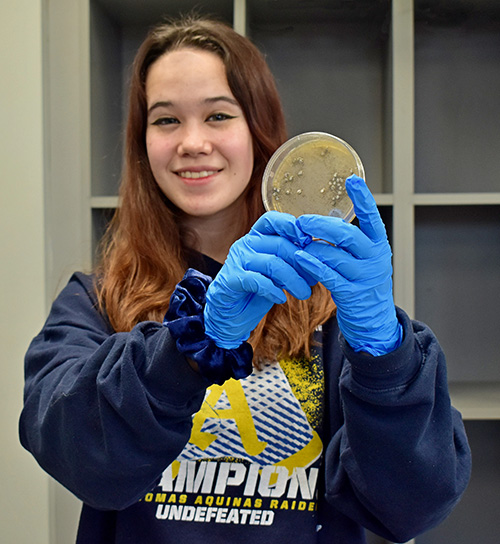 Kaitlyn Urruela shows a specimen of the fungus she grew at St. Thomas Aquinas High School to explore how the microbes might be used to break down waste plastic.