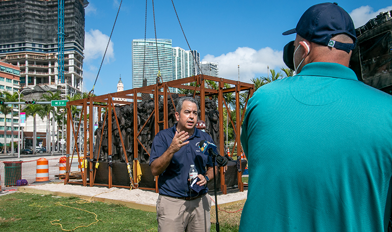 David Prada, archdiocesan director of the Building and Property Office, gives interviews to the media as workers from Florida Lemark finish installing the sculpture "Angels Unawares" in Miami's Bayfront Park, where it will be on display through April 8, 2021. The installation took place Feb. 9, 2021.