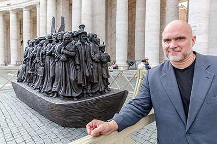 El escultor canadiense Timothy P. Schmalz posa junto a su escultura sobre los refugiados y la migración titulada 'Ángeles sin saberlo', en la Plaza de San Pedro, el 1 de octubre de 2019.