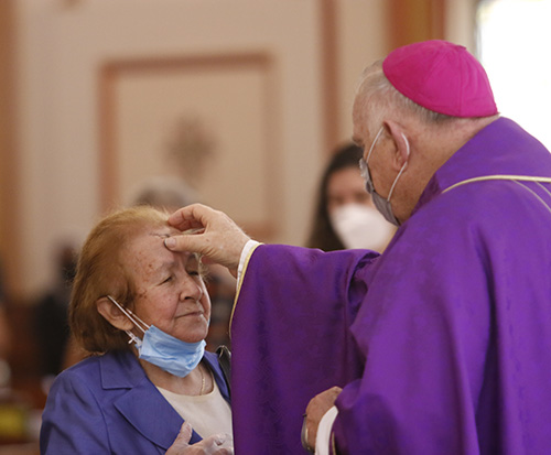 Archbishop Thomas Wenski imposes ashes on the faithful during Ash Wednesday Mass at Miami's historic Gesu Church, Feb. 17, 2021.