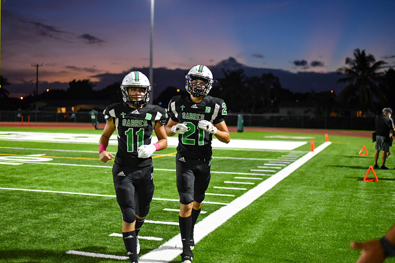 St. Brendan High wide receivers/defensive backs Jorge Cascudo (11) and Gabriel Granados (21) get off the field during an Oct. 23, 2020 game against Somerset Academy South Homestead, which St. Brendan won 48-7.