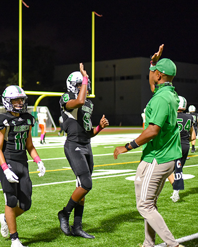 St. Brendan High wide receiver Jorge Cascudo (11) and quarterback Damari Charlton are congratulated by coach during a game they won 48-7 against Somerset Academy South Homestead, Oct, 23, 2020.