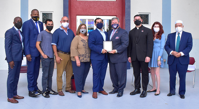 Family, friends and officials line up for a photo with Anthony Barroso after the St. Thomas University alumnus was honored March 2, 2021 for his action against an anti-Semitic graffito.