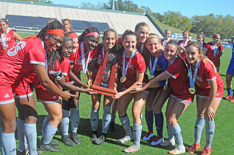 Cardinal Gibbons seniors get a group photo with the state-championship trophy following Cardinal Gibbons' 2-0 victory over Panama City Beach Arnold in the FHSAA Class 4A girls soccer championship game March 3, 2021, at Spec Martin Stadium in DeLand. The Chiefs won their first girls soccer championship.