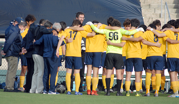 Jesuit Father Julio Minsal leads the Belen Jesuit Wolverines in prayer before their 2-1 overtime victory over the Tampa Jesuit Tigers, March 6, 2021 in the FHSAA Class 5A Boys Soccer Championship Game at Spec Martin Stadium in DeLand.