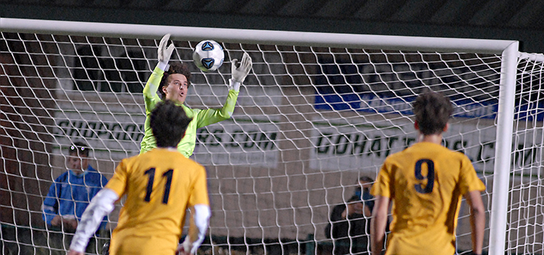 Belen Jesuit backup goalkeeper Jack Volpe leaps to make a save in front of teammates Alejandro Pereyra (11) and Matias Perinot (9) during the second overtime of the Belen Jesuit Wolverines' 2-1 overtime victory over the Tampa Jesuit Tigers, March 6, 2021 in the FHSAA Class 5A Boys Soccer Championship Game at Spec Martin Stadium in DeLand. Belen Jesuit denied seven-time champ Tampa Jesuit a repeat Class 5A title, and the Wolverines won their second state title and first since 2016.