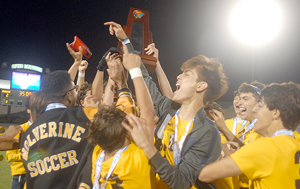 Belen Jesuit players celebrate with the championship trophy after the Wolverines' 2-1 overtime victory over the Tampa Jesuit Tigers, March 6, 2021 in the FHSAA Class 5A Boys Soccer Championship Game at Spec Martin Stadium in DeLand.