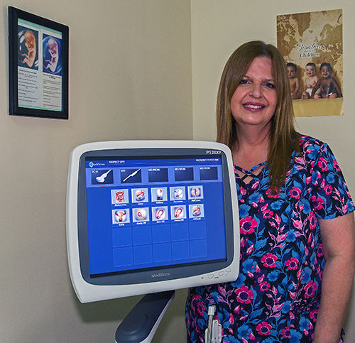 Rosita Porras, ultrasound technician, poses with the new ultrasound machine donated by the Knights of Columbus of St. Katharine Drexel Church to the North Broward Pregnancy Help Center. Auxiliary Bishop Enrique Delgado dedicated the new machine March 3, 2021, feast of St. Katharine Drexel.