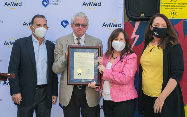 Posing with the proclamation from Miami-Dade County Mayor Daniella Levine Cava, from left: Paul Lowenthal, Camillus House chairman of the board, Patrick Morris, director of Civic and Philanthropic Partnerships for the mayor's office, Hilda Fernandez, Camillus House CEO, and Ashley Allen, senior vice president of Strategic Growth and Marketing for AvMed, whose donation of outdoor fitness equipment to Camillus House's main campus inspired the Fit 'n Trim celebration March 24, 2021.