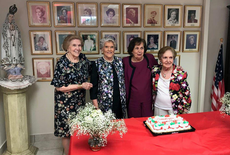 La primera presidenta del Ladies Auxiliary del Centro Hispano Católico, Emma McCormack, a la izquierda, se retrata junto a la última presidenta del grupo, Esperanza Rollan, y otros miembros durante una reunión en 2018 en sus oficinas situadas en la parte trasera del Centro Hispano en Wynwood.