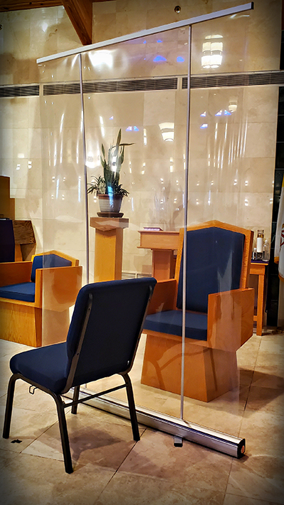 This is a modification made for those seeking a face-to-face confession at St. Edward Parish in Pembroke Pines. According to facilities manager Duane Meece, an issue originally encountered was that some penitents would speak a little too softly to be heard, and when asked to repeat, some would briefly lower their mask out of habit. "This portable, collapsible divider provides ongoing protection for both clergy and the penitent in such situations. Utilizing a more open environment versus a smaller room also aides in reducing any risk of COVID-19 exposure."